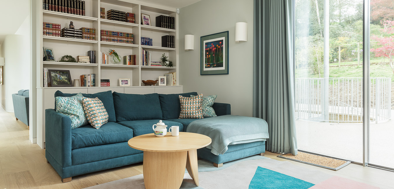 family room with blue chaise sofa and brightly coloured rug and bolia coffee table