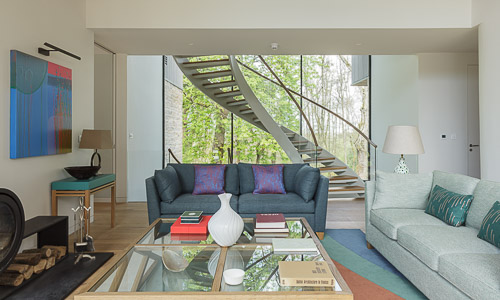 contemporary living room with DNA spiral staircase and views of the trees