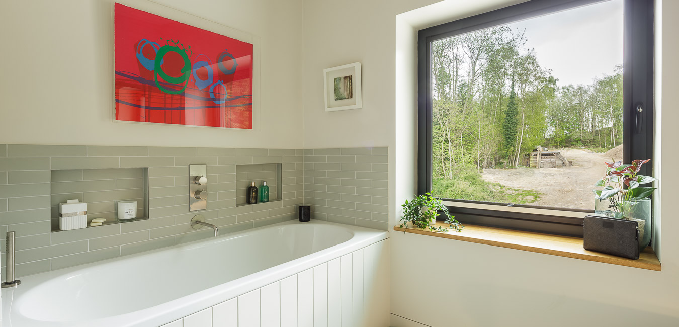 modern bathroom with green and white tiles and charlotte cornish painting 
